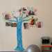 Su una parete si trova la raffigurazione di un albero colorato di blu con le foto appese dei genitori